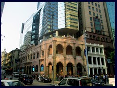 A modern glass highrise stands on a classic colonial building  on Av. de Almeida Ribeiro, near the Old Town.